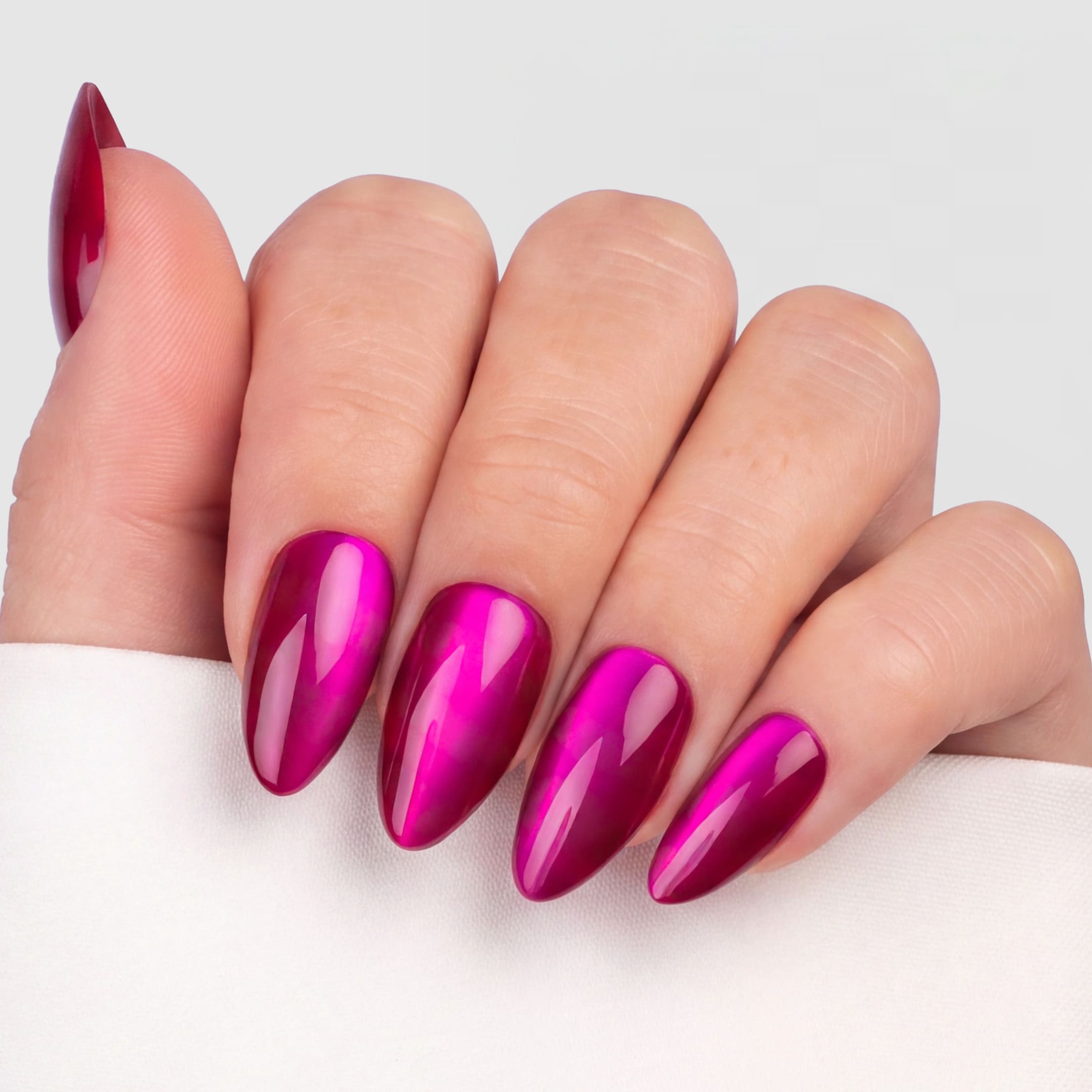 Cat Eye Hot Pink Almond är press-on naglar i vår klassiska almond-form, i en intensiv lila/rosa nyans med en skimrande cat eye-effekt.
