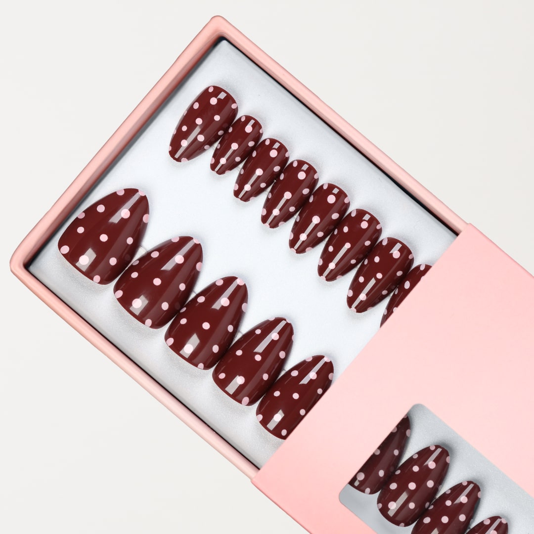 Bruna prickiga press-on naglar i almond-form med glansig finish.