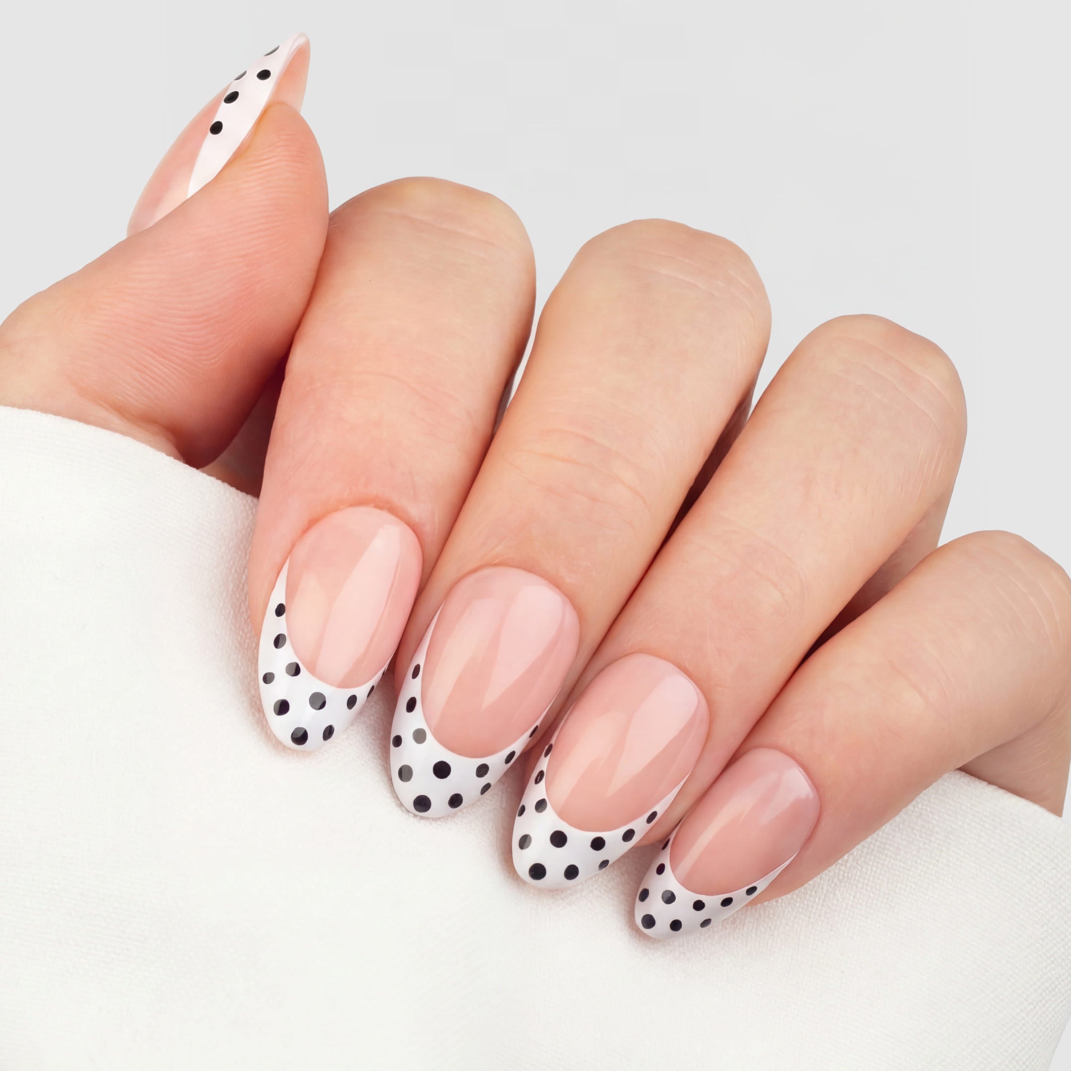 Dalmatian French Tip No. 102 är stilrena press-on naglar med en fräsch vit fransk tipp, dekorerad med svarta dalmatinprickar. Almond-formen är mjukt avsmalnande med rundad tipp, vilket skapar ett naturligt, förlängt intryck av fingret.