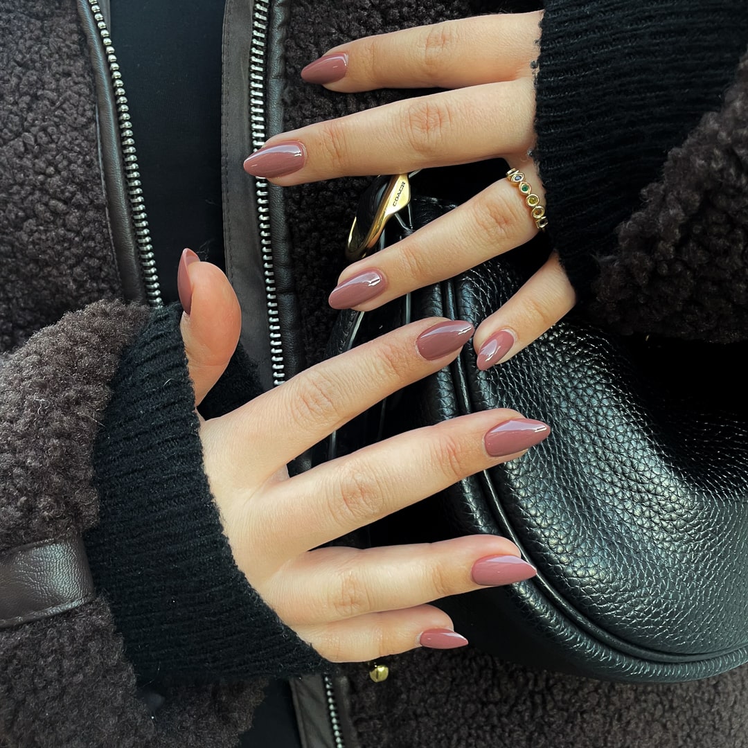 Mocha Melt Almond – bruna press on naglar i almond-form visade på hand.