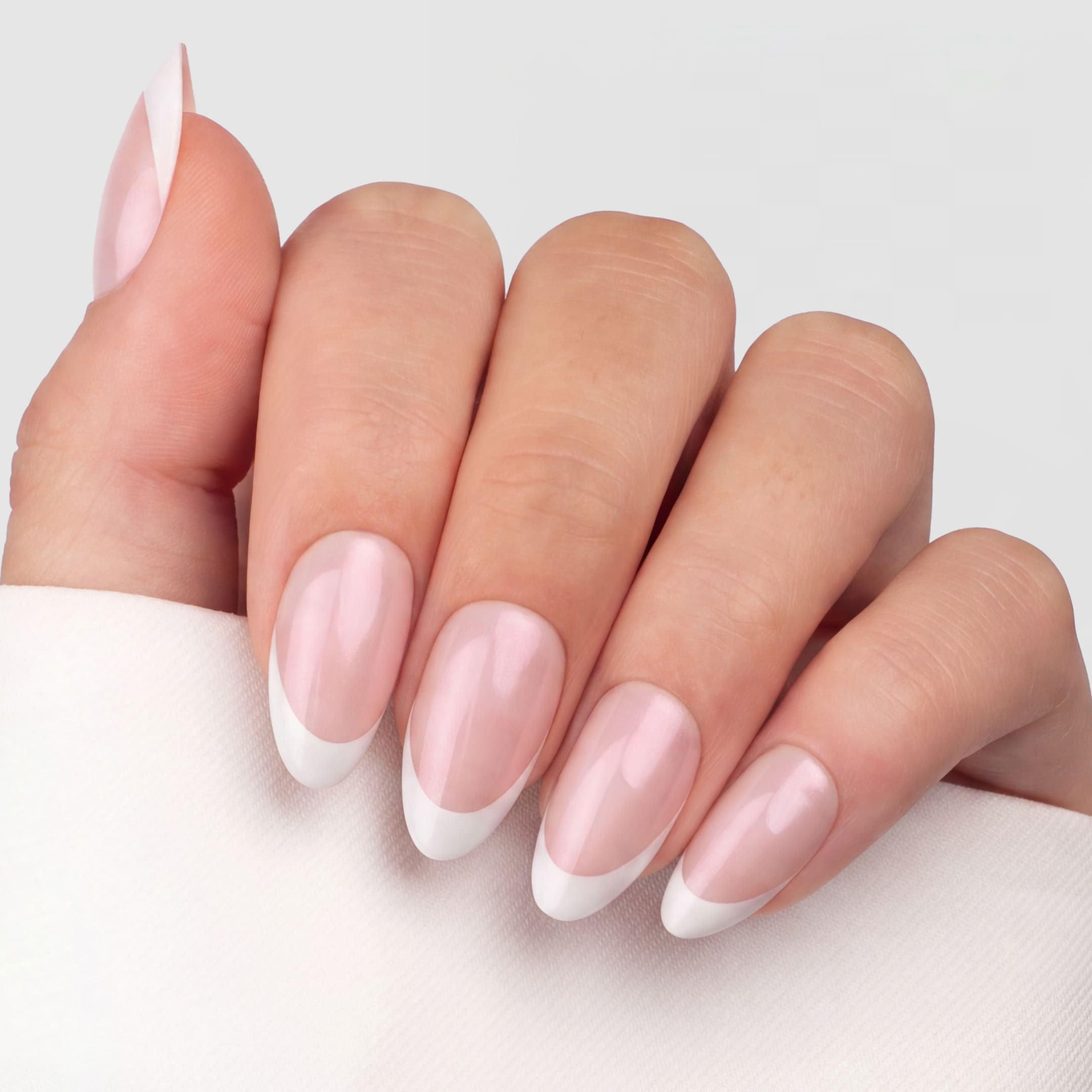 Shimmer French Tip Almond är en press-on i vår klassiska almond-form, med en mjuk rosa bas och klassiska vita tippar.