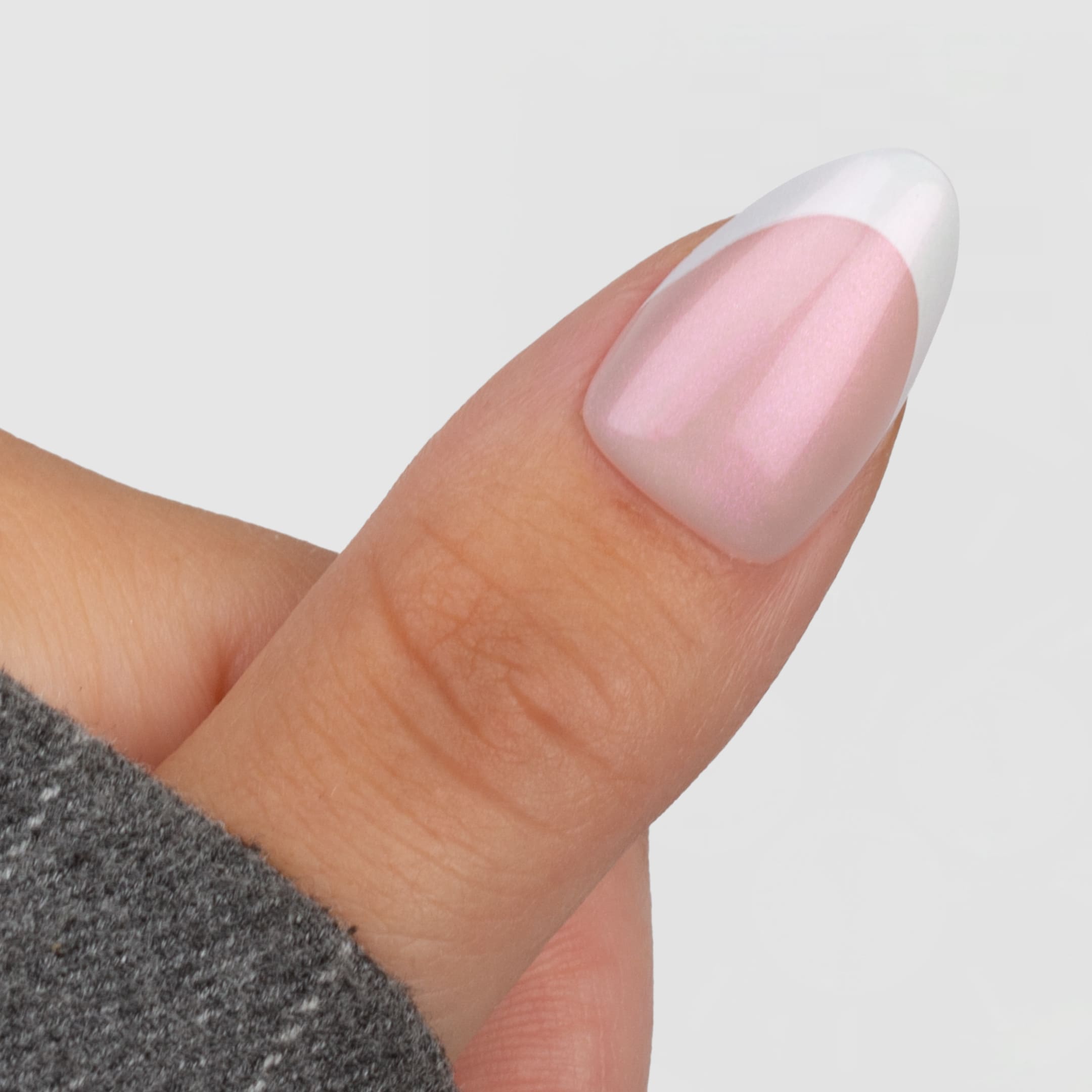 Shimmer French Tip Almond är en press-on i vår klassiska almond-form, med en mjuk rosa bas och klassiska vita tippar.