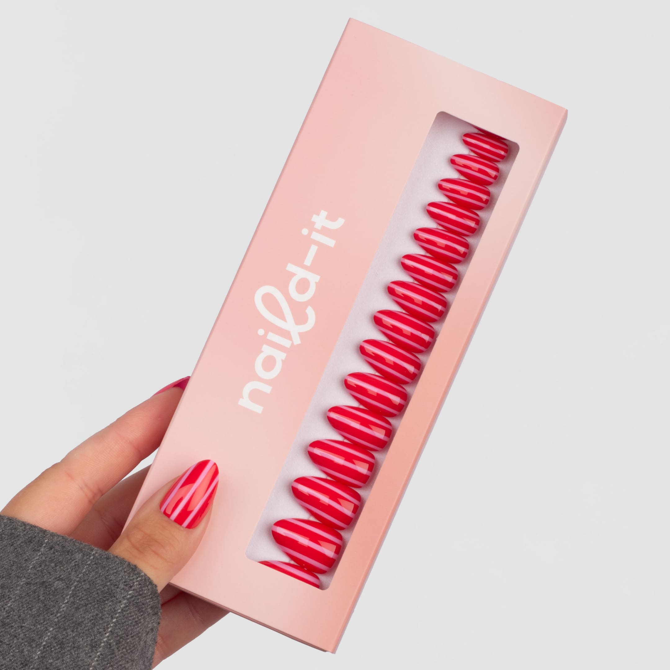 Sunset Stripes Almond är press-on naglar i vår klassiska almond-form med en randig design i röda och rosa toner.
