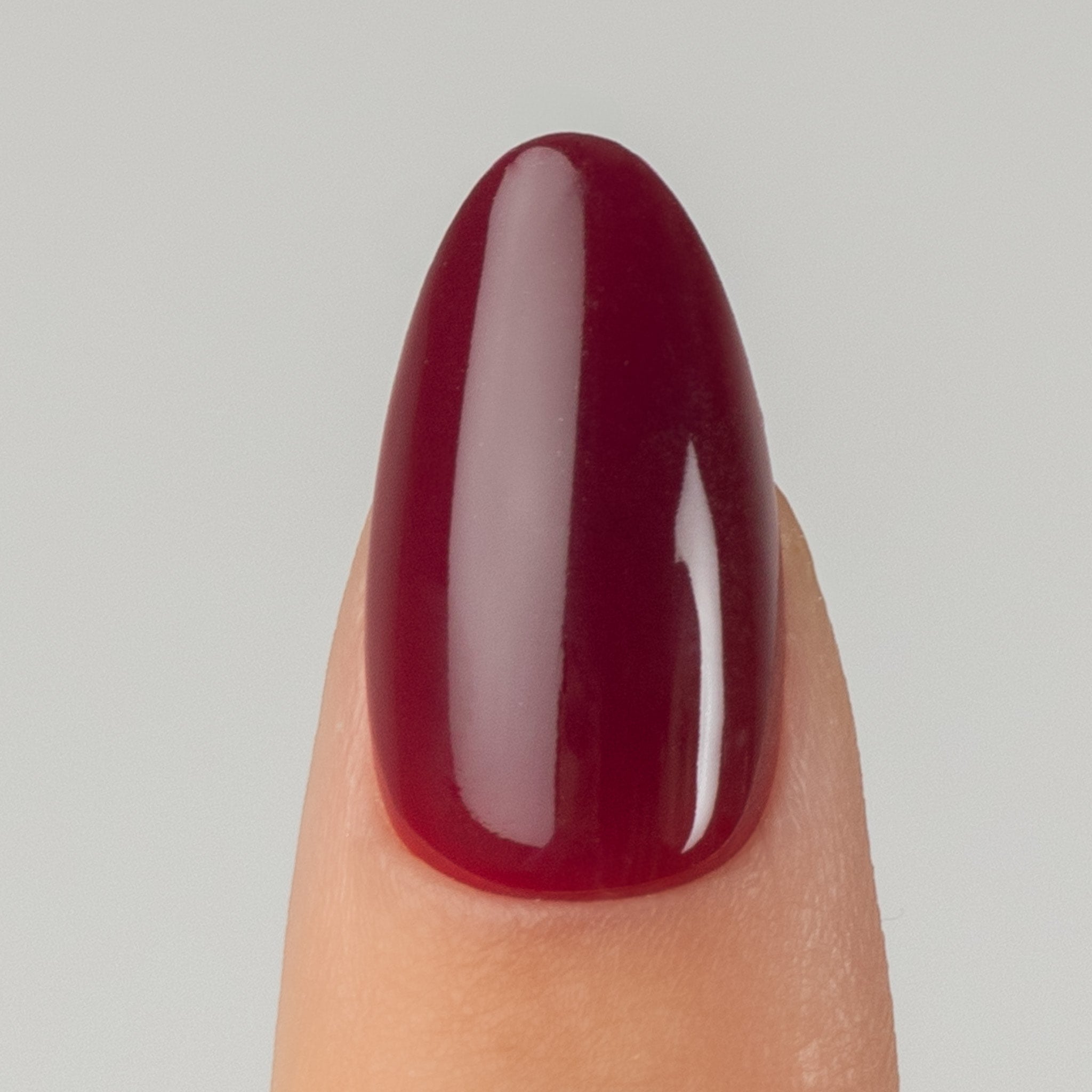 Bordeaux Almond – närbild på vinröd press on nagel i almond-form