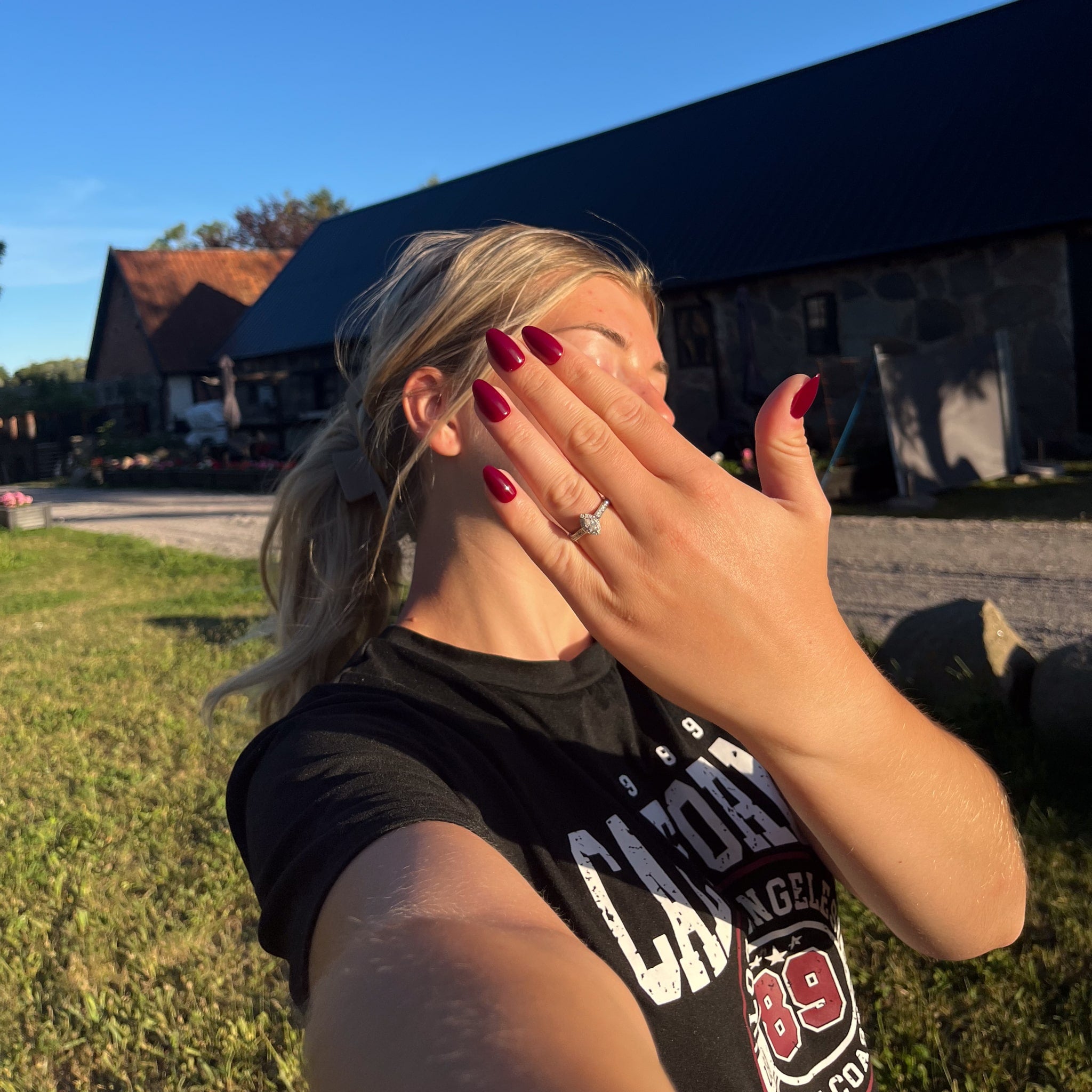 Bordeaux Almond – vinröda press on naglar i almond-form visade på modell utomhus