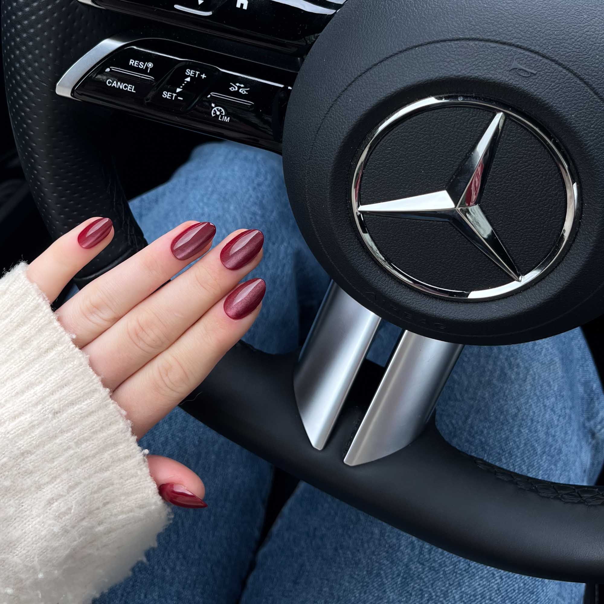 Cat Eye Ruby Almond press-on lösnaglar i almondform med djup röd nyans och skimrande cat eye-effekt