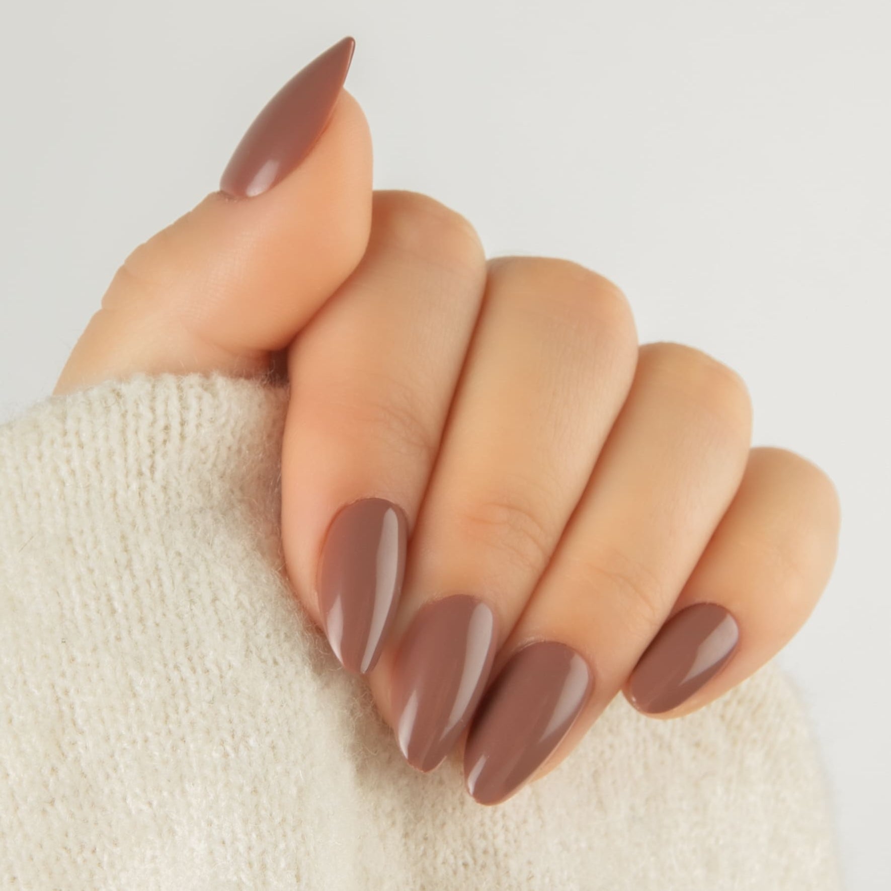 Mocha Melt Almond – bruna press on naglar i almond-form visade på hand.