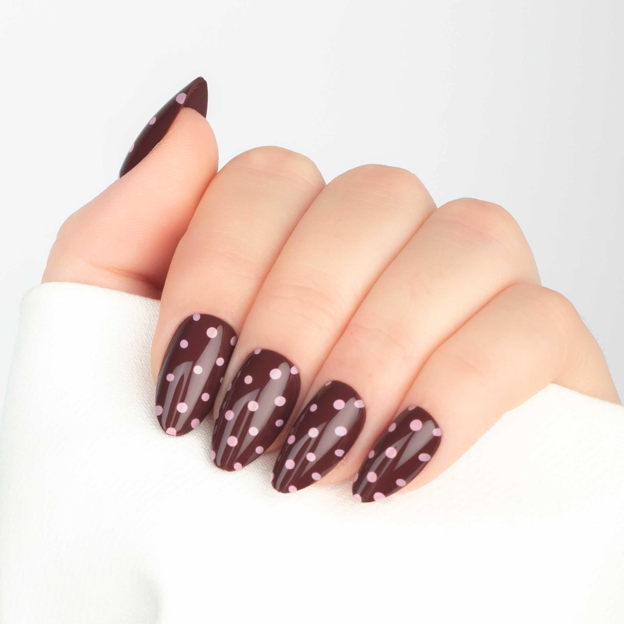 Bruna prickiga press-on naglar i almond-form med glansig finish.
