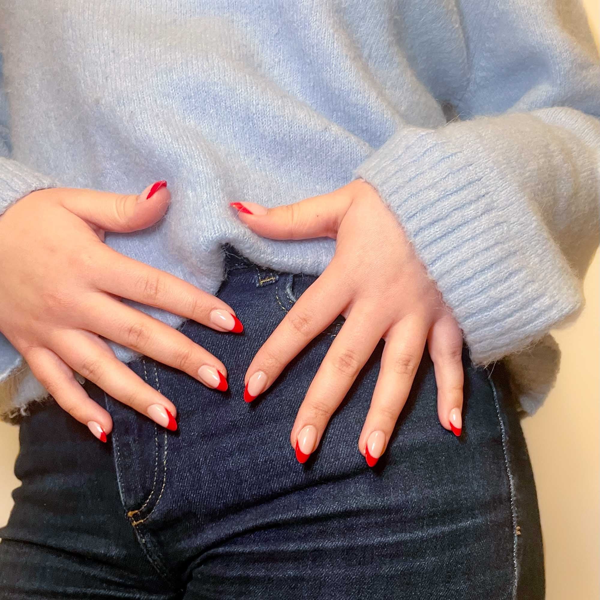 Press-on lösnaglar i almondform med röd fransk tipp och naturlig bas. Återanvändbara naglar som håller upp till 2 veckor med lim eller glue tabs.