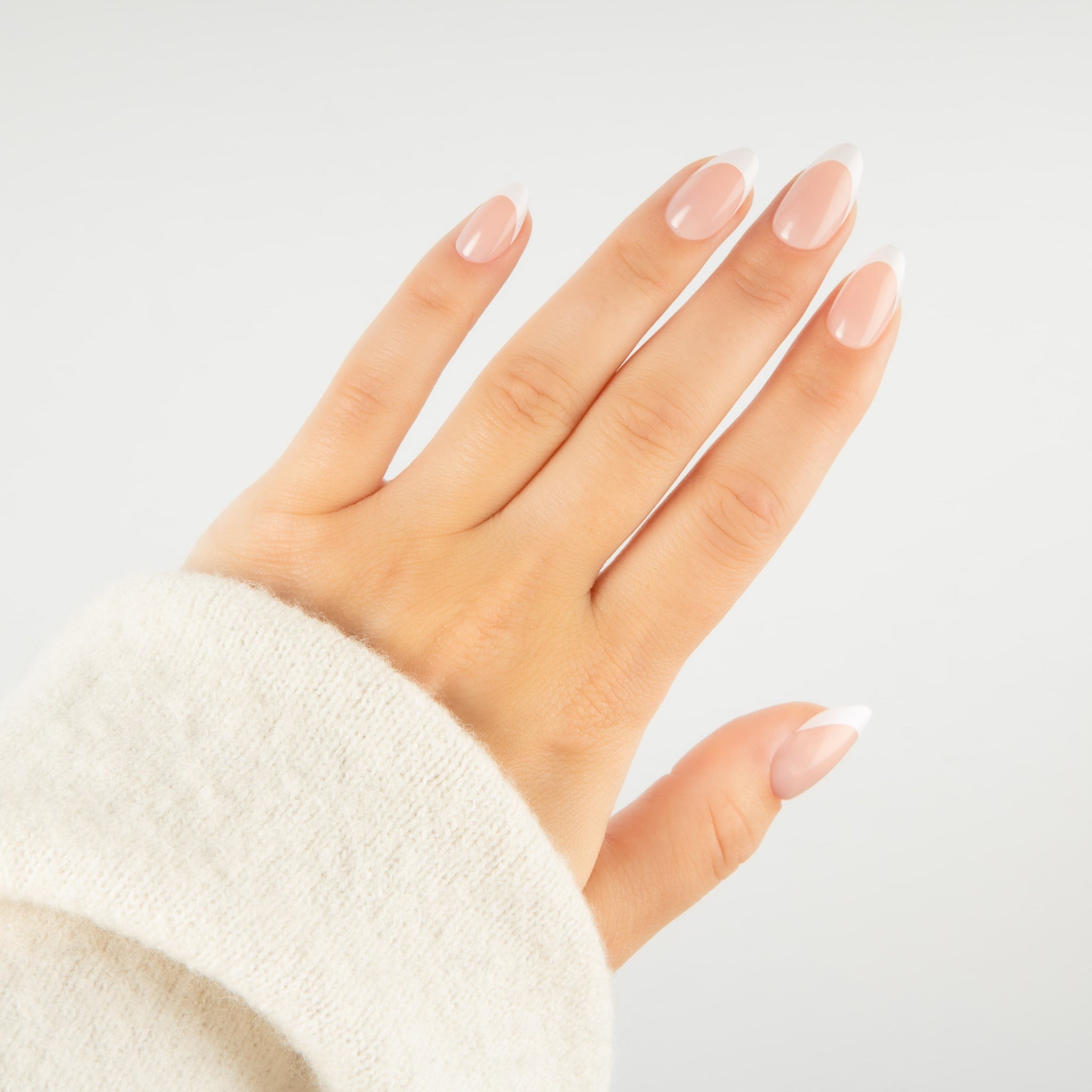 French Tip Almond – fransk manikyr press on naglar visade på hand i olika vinklar